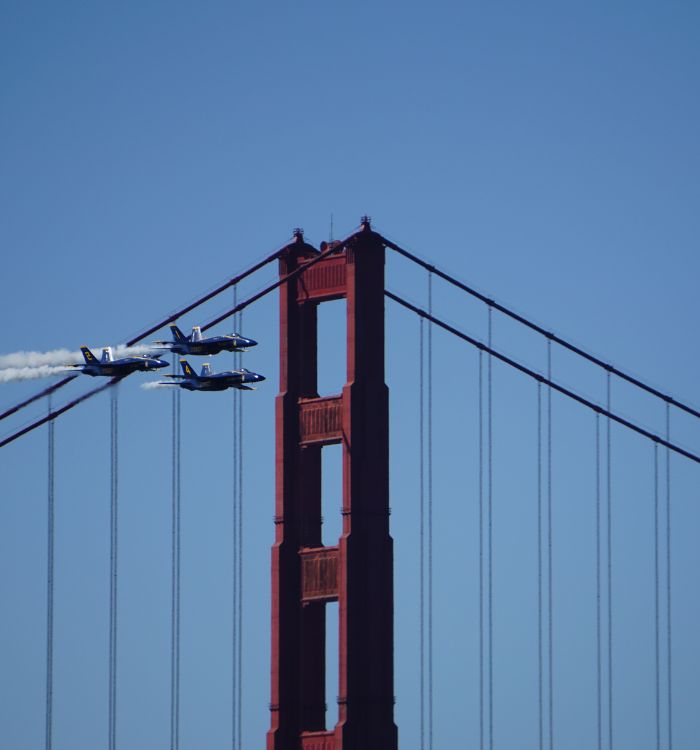 A formation of all six Blue Angels flying over the Golden Gate Bridge during the Fleet Week airshow