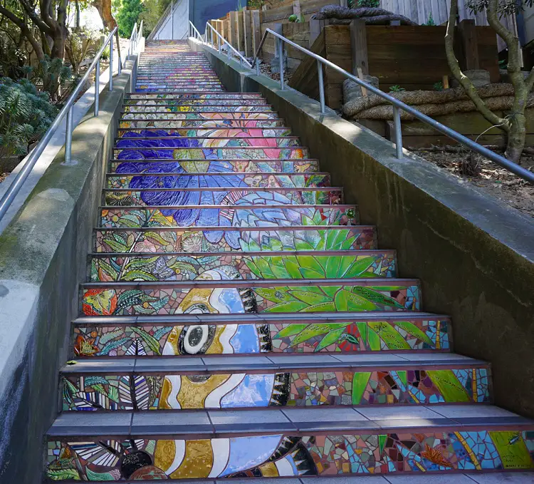A butterfly and flowers on a set of mosaic stairs.